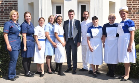 Andy Burnham, the mayor of Manchester, poses with nurses in uniforms to represent each decade of the NHS during a visit to Trafford hospital.