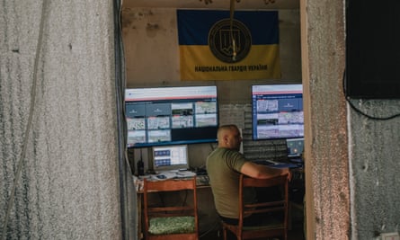 A man sits in front of computer screens at the control centre of the 15th brigade.