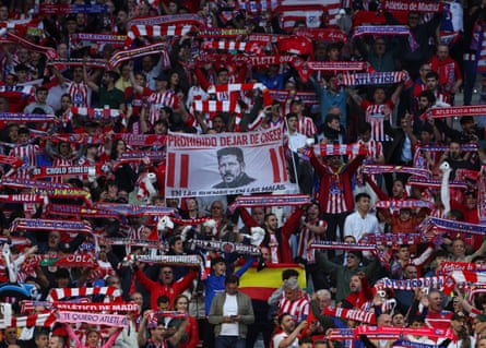 Atlético Madrid’s fans hold up scarves as well as a banner honouring their manager Diego Simeone