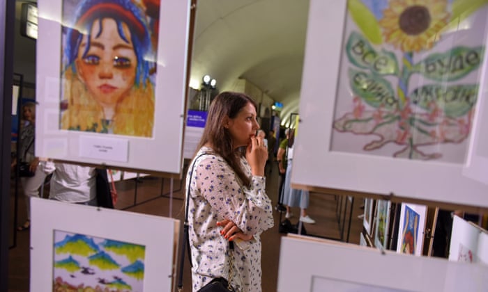 A visitor views children’s paintings in the Kyiv exhibition