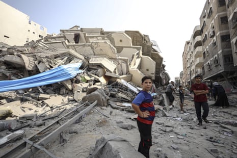 Palestinians walk on the rubble of destroyed houses after an Israeli airstrike on Gaza City.
