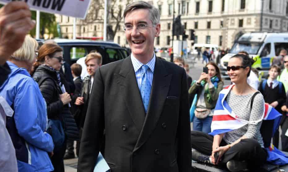 Jacob Rees-Mogg walks past anti-Brexit protesters outside the Palace of Westminster.