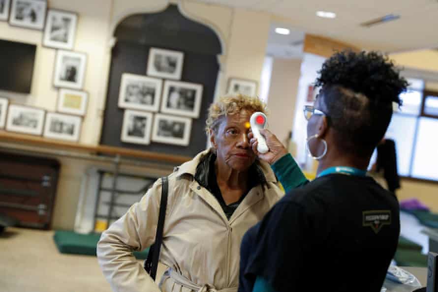 Ruth Cowan, 71, has her temperature taken upon entering St Anthony’s winter shelter in San Francisco.