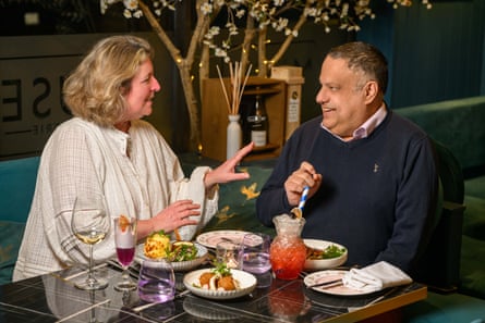 A woman and man facing each other across a restaurant table