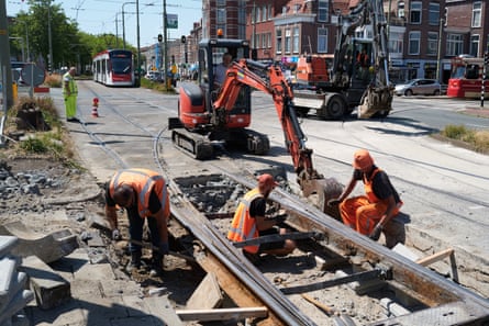 Construction workers repair railways for tramways as the Netherlands faces temperatures reaching 37C.