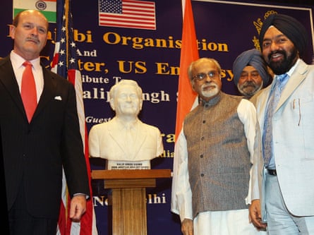 four men stand around bust of Saund