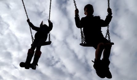 Two children in silhouette on swings