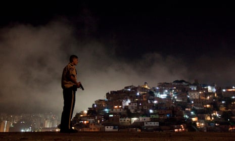 A police officer patrols the slum district of Petare in Caracas, Venezuela