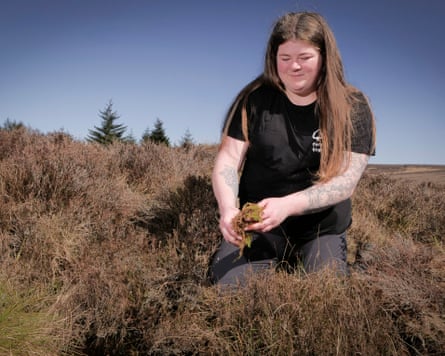 Rowan Hickman crouched down holding peat