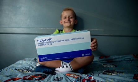 A small boy holds a box of medication