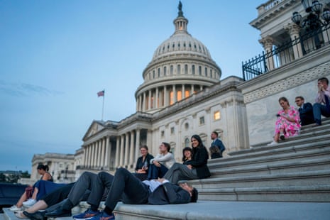 Senate staffers rest on the U.S. Capitol steps at sunrise as Republican lawmakers struggle to pass U.S. President Donald Trump's sweeping spending and tax bill, on Capitol Hill in Washington, D.C., U.S., July 1, 2025.