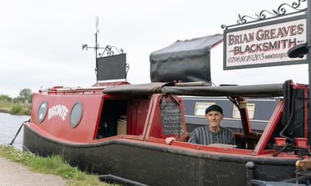 Brain Greaves on board his red canalboat with his business sign on top