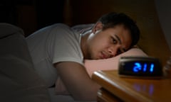 man suffering from insomnia lying in bed