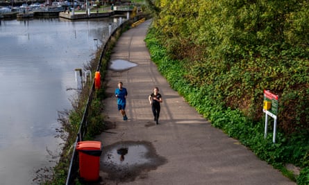 People running by river at Teddington lock.