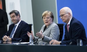 Angela Merkel, centre, with Bavaria’s premier, Markus Söder, left, and Peter Tschentscher, first mayor of Hamburg, at a press briefing