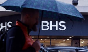A man with an umbrella outside a branch of BHS
