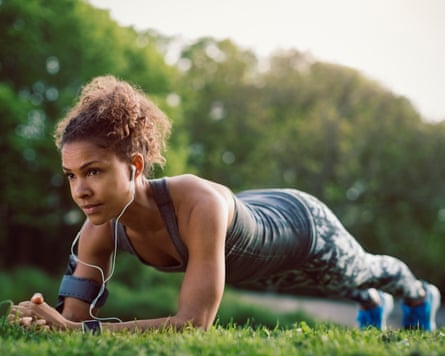 A woman doing a plank in a park