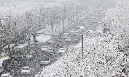 Cars move slowly on a snow-covered road in southern Seoul, South Korea, amid a heavy snow alert