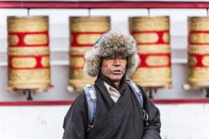 A local chanting silent prayers after turning prayer wheels.