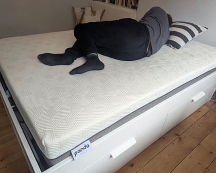 A man lies on his side on a Panda Hybrid Bamboo Mattress