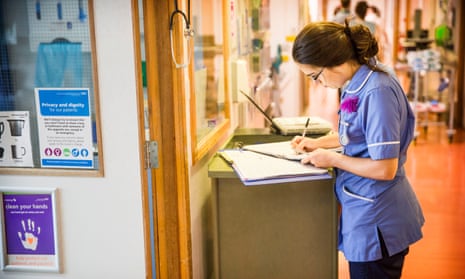 Nurse making notes in a ward