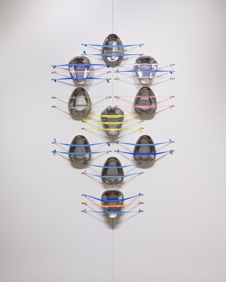 A series of bed pans attached to a wall with colourful tourniquets