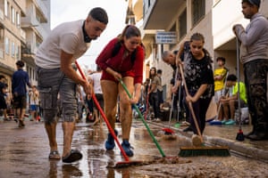 People use brushes on a muddy street