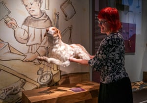 A woman holds a stuffed dog as she places it on a small table