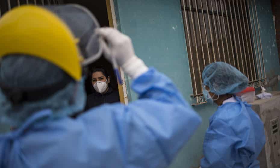 medical workers talk to masked person outside home