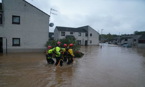 Emergency workers wade through flood water in Brechin, Scotland, as Storm Babet batters the country.