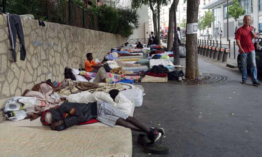 Migrants sleep on mattresses on the pavement in a makeshift camp in Paris.