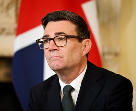 Andy Burnham in a suit and tie in front of the union flag