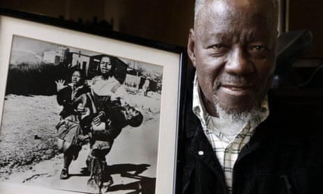 Sam Nzima poses with his famous photograph showing Hector Pieterson being carried after being shot dead by police during the 1976 Soweto uprising