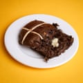 A Sainsbury’s Taste the Difference double chocolate & cherry hot cross bun, sliced, toasted and buttered, on a white plate