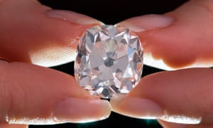 A member of Sotheby's staff poses holding a 26.27 carat, cushion-shaped, white diamond, for sale at Sotheby's auction house