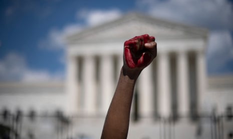 An abortion rights demonstrator raises their fist, painted in red, in the air during a rally in front of the US supreme court, on Saturday.