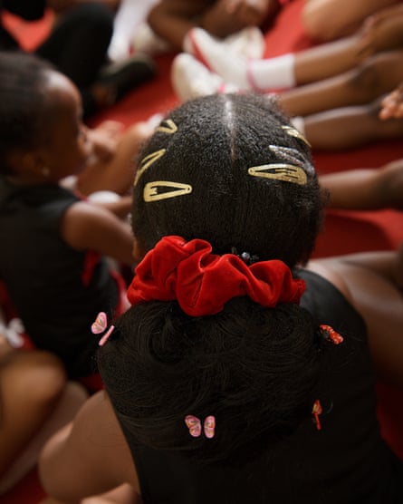 Close-up of the hair of a member of the Lagos Cheer Nigeria cheerleading team, with a red scrunchie and clips in it