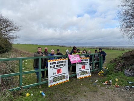 Campaigners against the datacentre stand by a gate holding signs