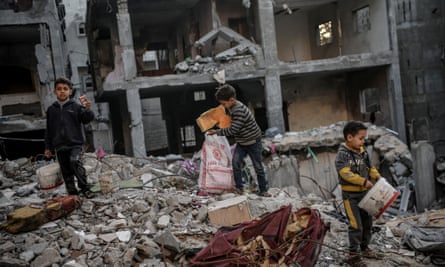 Boys search for paper and cardboard under rubble to use as fuel in Rafah, Gaza