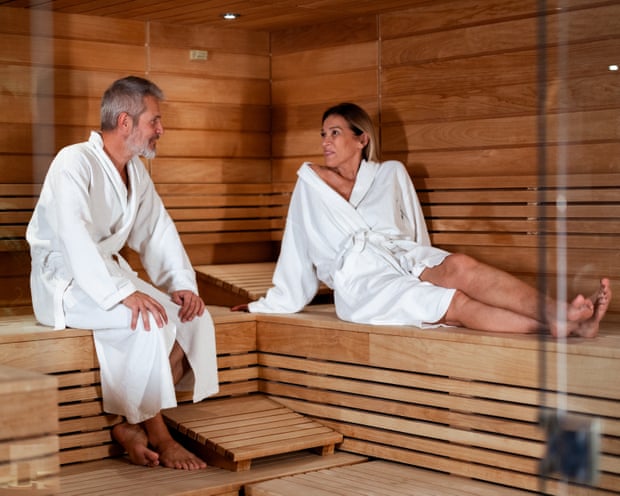 A mature couple relaxing together in wooden sauna