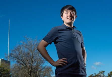 A man stands with his hands on his hips in front of a blue sky