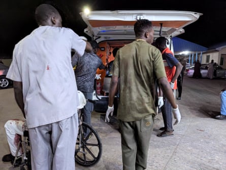 Members of the Nigerian Red Cross helping wounded victims into an ambulance.
