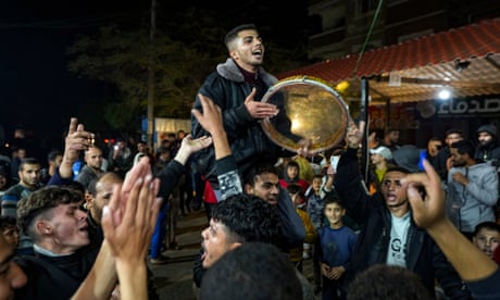 Palestinians celebrate the announcement of a ceasefire deal between Hamas and Israel in Deir al-Balah, Gaza.