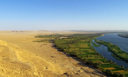 The site of Amarna viewed from the desert cliffs to the north of the city. Cultivation runs along the edge of the Nile, giving way to low desert extending to the cliffs.