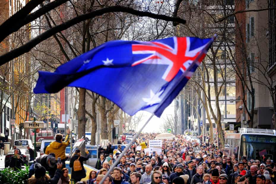 Les manifestants brandissent un drapeau australien lors du rassemblement anti-verrouillage à Melbourne samedi.