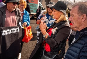 People look at a man holding a ‘Mad for it’ T-shirt.