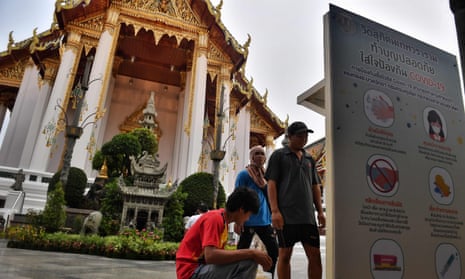 Workers install hand sanitiser dispensers at Wat Suthat Thepwararam temple in Bangkok.