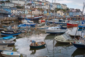 A man makes his way back to the shore after tending to his boat in Brixham, Devon.