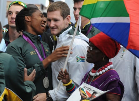 Semenya shares a joke with fellow medallist Cameron van der Burgh as her grandmother Mmabuthi Segale looks on as the team is mobbed by fans at the airport.