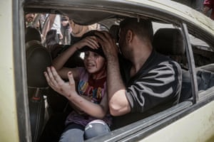 Injured Palestinian children are moved away from the site of an Israeli airstrike in the Gaza Strip